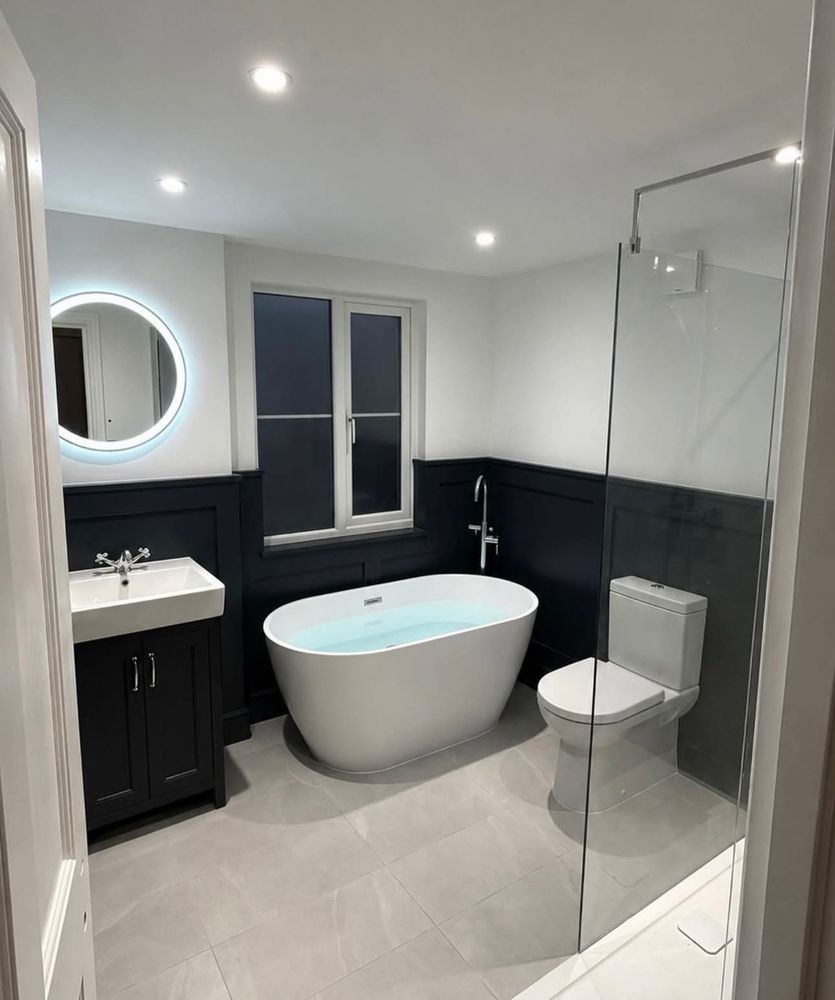 Bathroom with freestanding bath, dark panelling and LED mirror