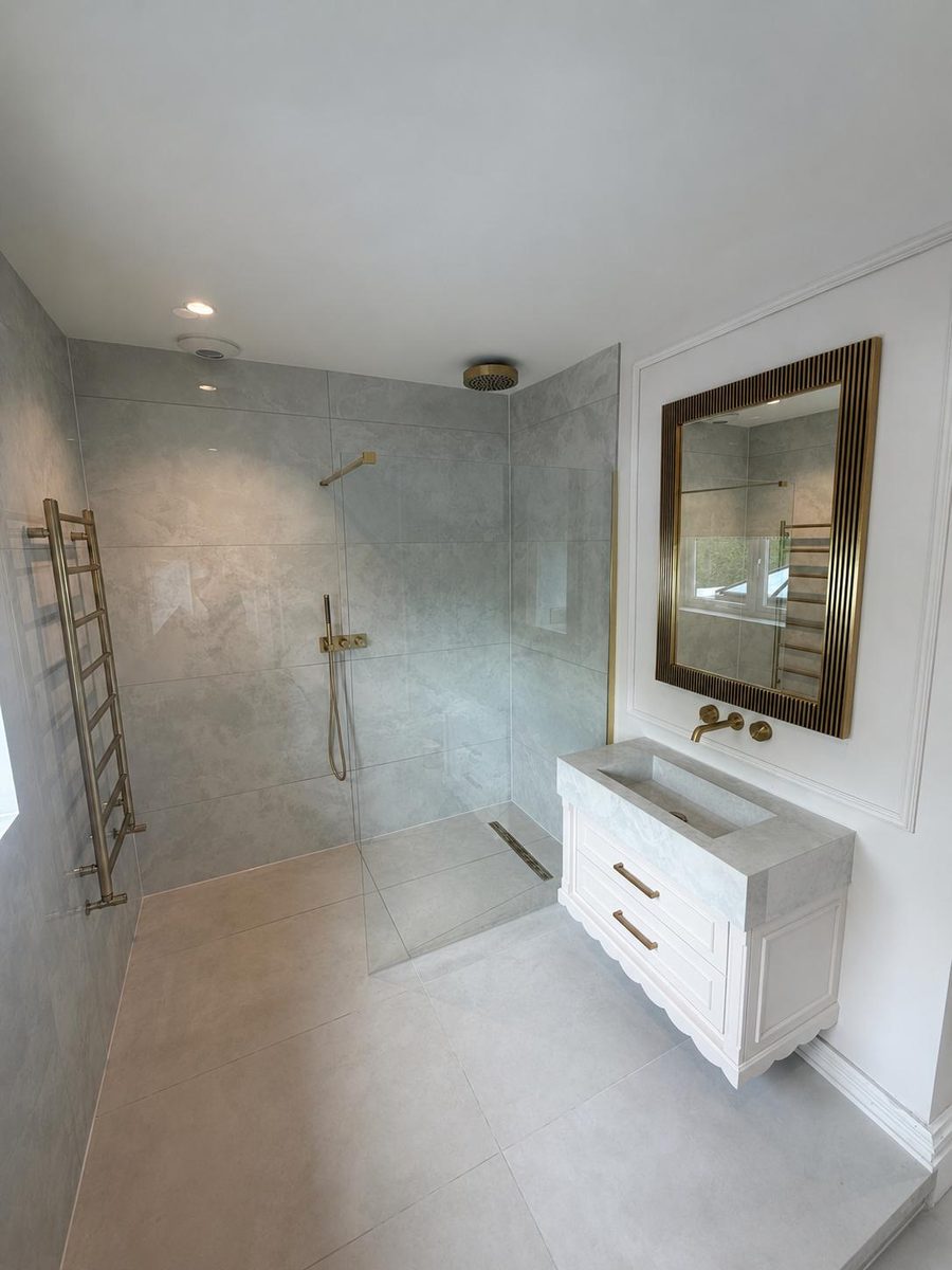 Bathroom refit in Liverpool — grey marble-effect tiling with brushed gold fittings